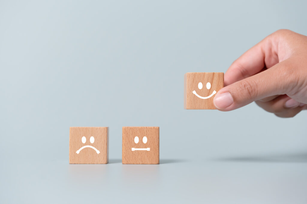 Concept of customer satisfaction review. Wooden blocks with facial expression and the "Best score" was chosen.